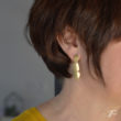 Femme vue de profil portant une boucle pendante médium ELLES